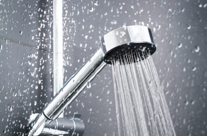 Close up of a shower head with running water.