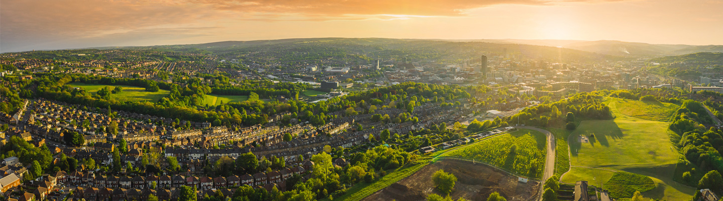 Ariel shot of an urban landscape, with fields in the foreground and background